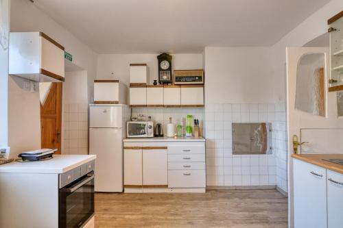 a kitchen with white appliances and white cabinets at Farmhouse Blackberry Pool & Wellness- Happy Rentals in Vransko