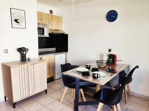 - une cuisine avec une table et des chaises dans la chambre dans l'établissement Joli appartement aux Minimes avec Parking, à La Rochelle