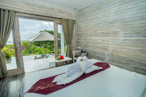 The Puncak Private Villa في نوسا ليمبونغان: غرفة نوم مع سرير وإطلالة على المحيط