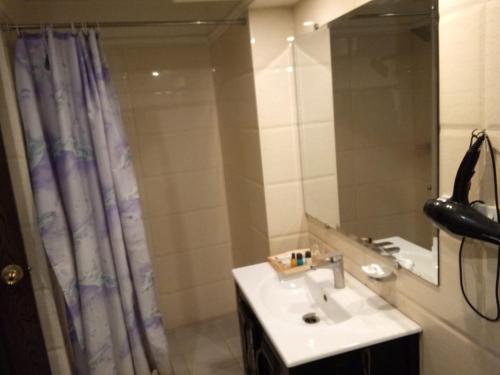 a bathroom with a sink and a shower with a mirror at Hotel Javson in Sialkot