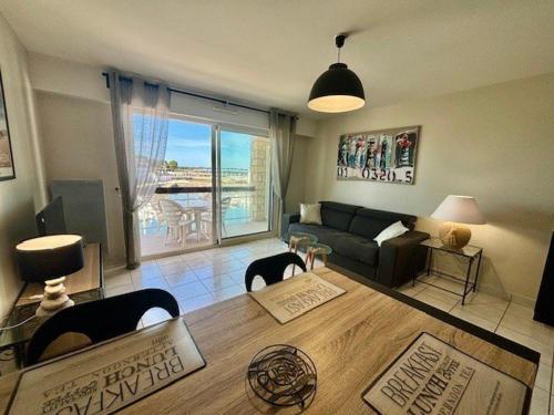 ein Wohnzimmer mit einem Sofa und einem Tisch in der Unterkunft Appartement Quiberon, 2 pièces, 4 personnes - FR-1-478-78 in Quiberon