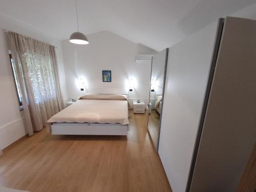 a small bedroom with a bed and a mirror at CASETTA TRA GLI ULIVI in Umag