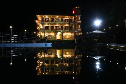 a building with a reflection in the water at night at Sukoon Dk in Rudraprayāg