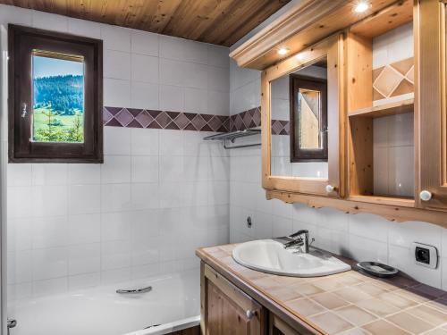 a bathroom with a sink and a tub and a mirror at Appartement Megève, 3 pièces, 4 personnes - FR-1-453-275 in Megève