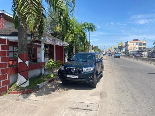 Un todoterreno negro estacionado al lado de una calle en Hotel GIRMA-2, en Pointe-Noire