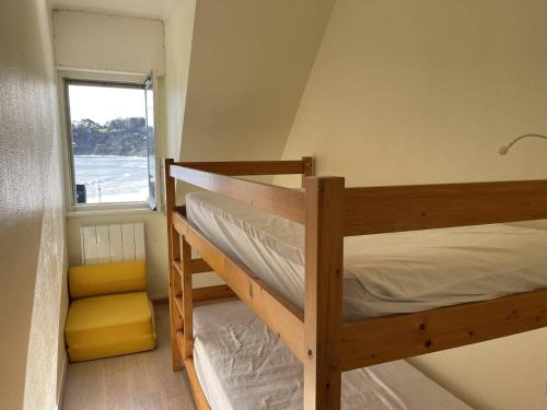 deux lits superposés dans une chambre avec fenêtre dans l'établissement Maisonnette à Perros-Guirec près de la plage avec parking - FR-1-368-415, à Perros-Guirec