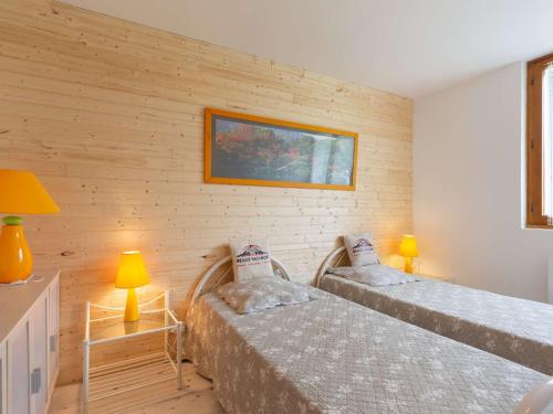 deux lits dans une chambre aux murs en bois dans l'établissement Appartement cosy 2 chambres avec parking et balcon à Saint-Lary-Soulan - FR-1-296-310, à Saint-Lary-Soulan