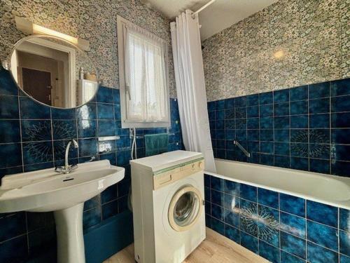 La salle de bains est pourvue de carrelage bleu, d'un lave-linge et d'un lavabo. dans l'établissement Quiberon - Appartement 3 pièces avec Balcon, Parking, Proche Plage et Centre-ville - FR-1-478-280, à Quiberon