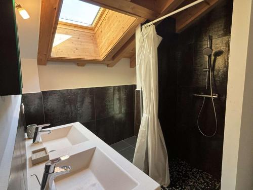 uma casa de banho com um chuveiro e um lavatório branco em Chalet Notre-Dame-de-Bellecombe, 8 pièces, 15 personnes - FR-1-595-1 em Notre-Dame-de-Bellecombe