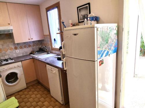 une cuisine avec un réfrigérateur et une machine à laver dans l'établissement **Charmant T2 4 pers, terrasse jardin, prox. plage, park. privé, quartier Pinède** - FR-1-607-160, au Cap d'Agde