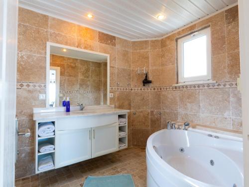 y baño con bañera, lavabo y espejo. en alanya polat holiday village, en Alanya