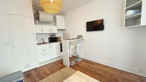 a kitchen with white cabinets and a counter in a room at Coquet Studio Refait a Neuf en Avril 2024 in Paris