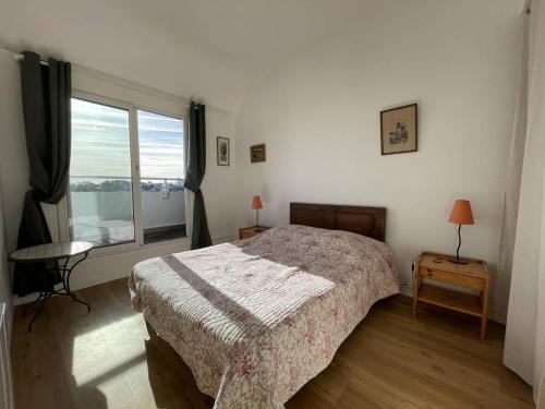 une chambre avec un lit et une grande fenêtre dans l'établissement Appartement avec vue sur mer, proche plage, terrasse et parking à Perros-Guirec - FR-1-368-417, à Perros-Guirec