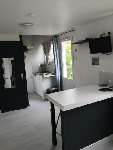 une cuisine avec un comptoir blanc et une porte noire dans l'établissement Emplacement central - 300m de la plage - studio F, à Berck-sur-Mer