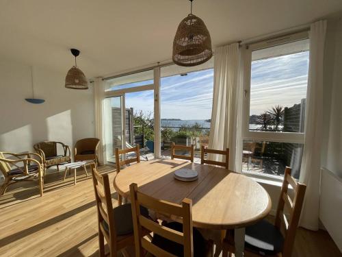 une salle à manger avec une table et une grande fenêtre dans l'établissement Appartement avec vue sur mer, proche plage, terrasse et parking à Perros-Guirec - FR-1-368-417, à Perros-Guirec