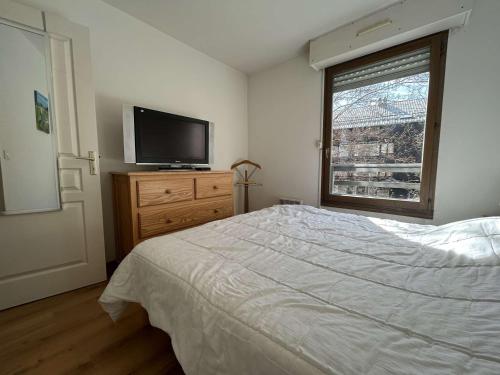 a bedroom with a bed and a flat screen tv at Spacieux Appartement 4 Pièces, 6 Couchages, Proche Pistes et Commerces, La Salle-les-Alpes - FR-1-330F-77 in Serre Chevalier
