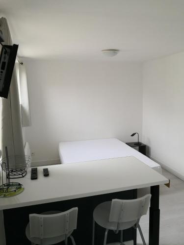 une chambre avec une table blanche et deux chaises dans l'établissement Emplacement central - 300m de la plage - studio F, à Berck-sur-Mer