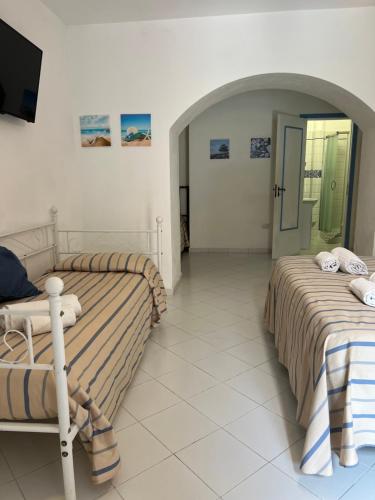 a room with two beds and a tv in it at La Casa al Mare Vulcano in Vulcano