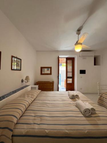 ein großes Bett in einem Schlafzimmer mit Deckenventilator in der Unterkunft Residence Al Mare in Vulcano