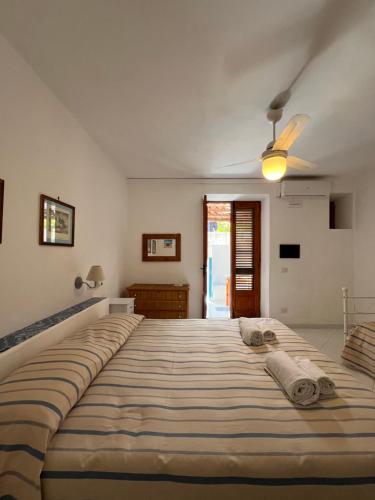 un grande letto in una camera da letto con ventilatore a soffitto di Residence Al Mare a Vulcano