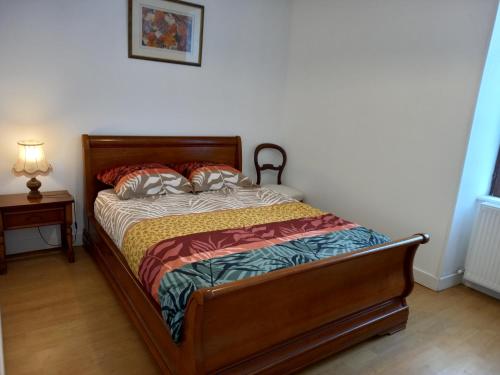 a bedroom with a bed and a night stand with a lamp at Maison vacances 8 voyageurs in Mont-Saint-Jean