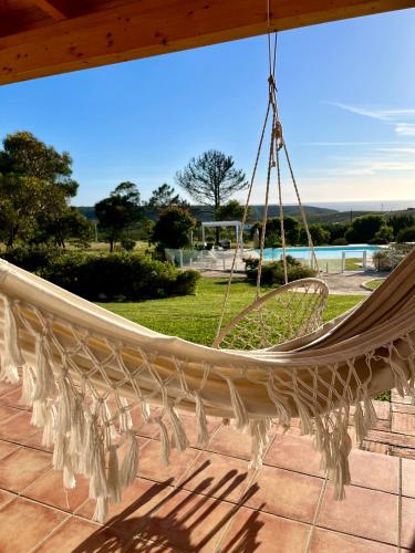 a hammock on a patio with a view at Herdade Monte Do Sol in Aljezur