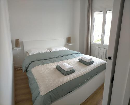 um quarto com uma cama com duas toalhas em La Dunette, appt cozy à 150 m de la plage em Merlimont