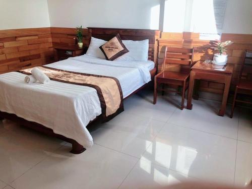 een slaapkamer met een bed en een bureau en een bed sidx sidx sidx bij HOÀNG GIA BẢO KON TUM in Kon Tum