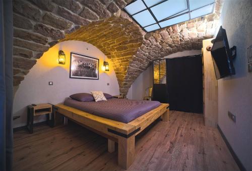 a bedroom with a bed in a brick wall at La Chapelle Industrielle in Issenheim