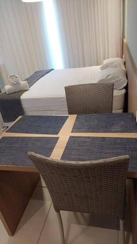 um quarto com uma mesa e duas cadeiras e uma cama em Apto no Villas BobZ - Barra Grande em Cajueiro