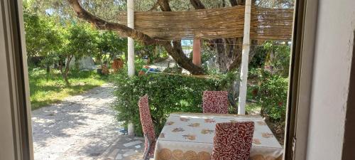Ein Tisch und Stühle stehen vor einem Fenster in der Unterkunft Novruzi Complex in Vlorë