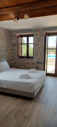 a bedroom with a large white bed in a room at Koukouri Suites in Areopolis
