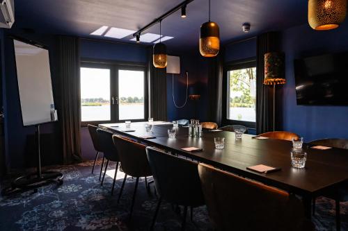 a dining room with a long table and chairs at Boutique Hotel de Bungelaer in Beers