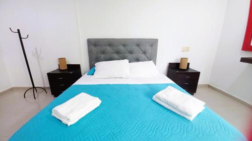 a large bed with two white towels on it at Apartasuite Morros Vitri in Cartagena de Indias