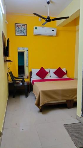 Habitación amarilla con 2 camas y TV. en Hotel sagar deluxe en Hospet