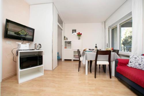 salon z czerwoną kanapą i stołem w obiekcie Riva Lago e Spiaggia Apartment - Happy Rentals w mieście Riva del Garda