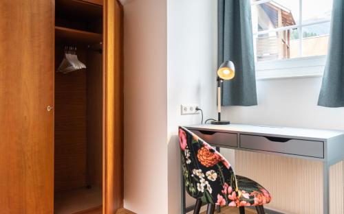 a bedroom with a desk and a chair next to a window at Apartment Sonnleitner in Kötschach
