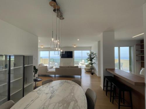 a living room with a table and a living room with the ocean at Gli Scogli Luxury Residence Hotel in Chiavari