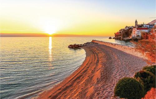 a beach with the sun setting over the water at Awesome Home In Katuni Rubici, Prpusa in Šestanovac