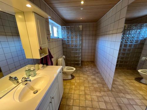 a bathroom with a sink and a toilet at Sea & Mountain View 3 Bedroom in Leynar