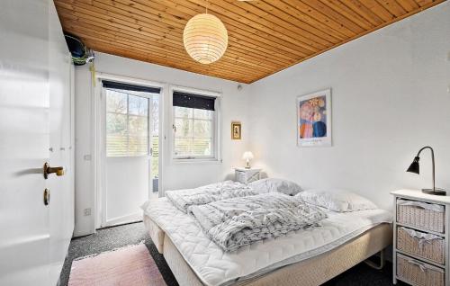 1 dormitorio con cama y techo de madera en Gorgeous Home In Melby With Kitchen, en Melby