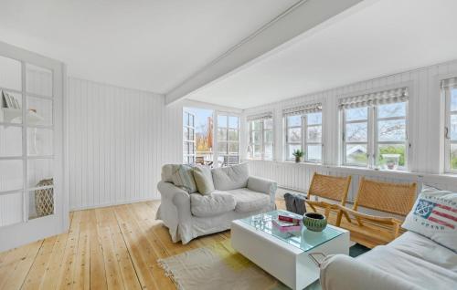 a living room with white furniture and windows at 3 Bedroom Awesome Home In Hornbæk in Hornbæk