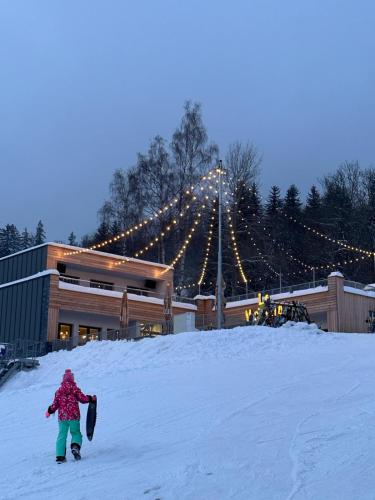 a person is walking in the snow with a snowboard at La Victoria in Janske Lazne