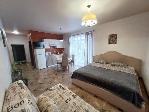 a bedroom with a large bed and a kitchen at Гостьовий будинок Осокорки in Kyiv