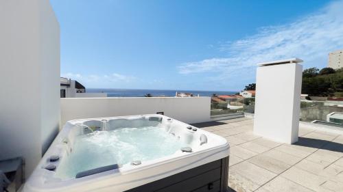 a bath tub sitting on top of a balcony at Oceanside East in Ponta Delgada