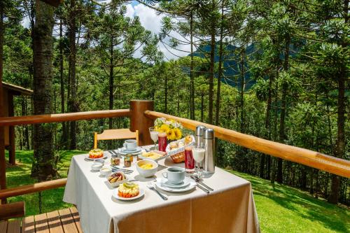 a table with food and drinks on top of a balcony at Pousada Casa Campestre in Gonçalves