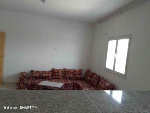 a living room with a couch and a window at Résidences Porte de désert Douz in Douz