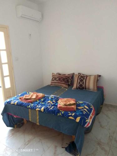 a bed in a room with two pillows on it at Résidences Porte de désert Douz in Douz