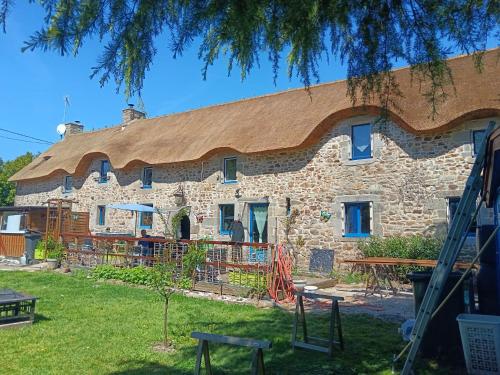 a stone house with a straw roof at La Chaumière en Bellevue in Muzillac