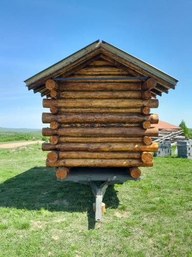 una gran casa de madera en un puesto en el césped en Bungalov, en Miroč